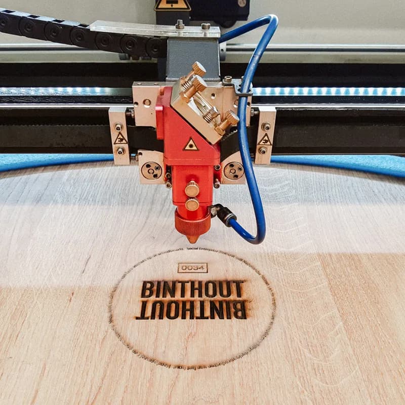 Houten snijplank met een gegraveerd logo.